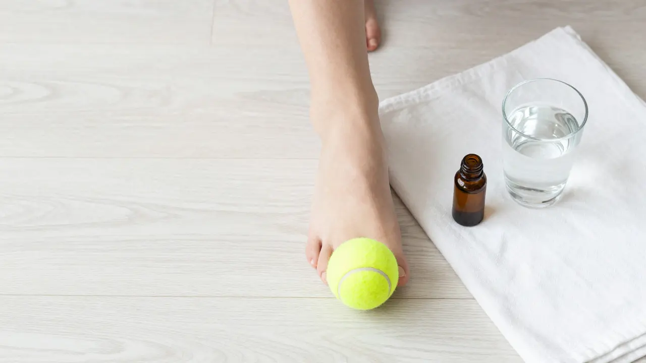 Domácí stimulace reflexních bodů pomocí tenisového míčku a esenciálního oleje.
